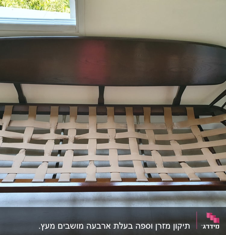 רצועות בד חומות שזורות על מסגרת עץ של ספה